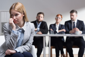 Stressed applicant and management members sitting beside table